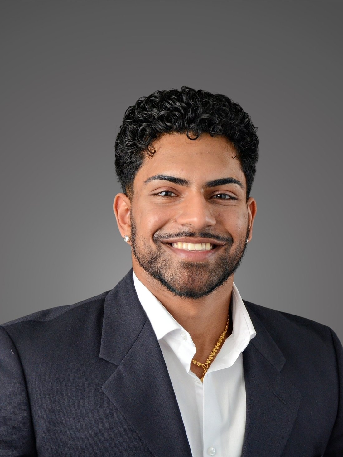 Headshot of Jason Varghese in a navy suit and white shirt
